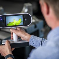 a working mechanician holding a device
